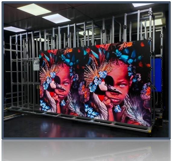 Large printed banner displaying a vibrant portrait of a child surrounded by blue flowers, mounted on a metal frame in a print shop or studio.